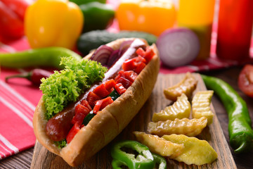 Hot dogs and vegetables on wooden cutting board