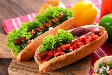 Hot dogs and vegetables on wooden cutting board