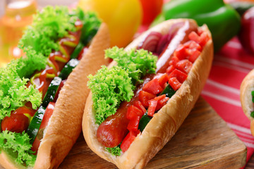 Hot dogs and vegetables on wooden cutting board
