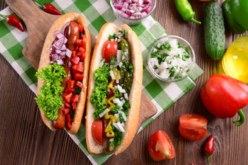 Hot dogs and vegetables on wooden cutting board