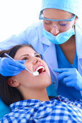 Woman dentist working at her patients teeth