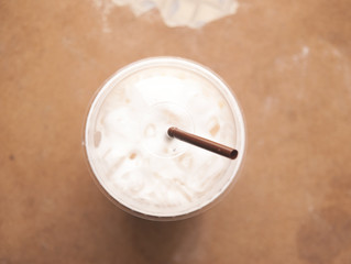 Iced coffee with milk or cream on top view background