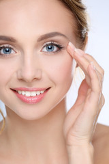 Fototapeta premium Young woman touching her face isolated on white background