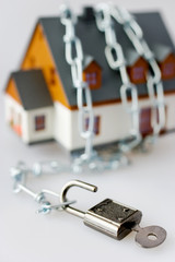 Fototapeta premium family house and metallic chain as a protection - key lock security