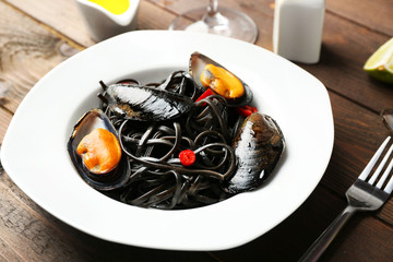 Cooked pasta, mussel and lime on brown wooden background
