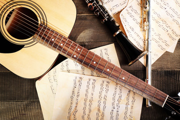 Fototapeta na wymiar Acoustic guitar, soprano saxophone, violin, flute and note sheets on wooden background