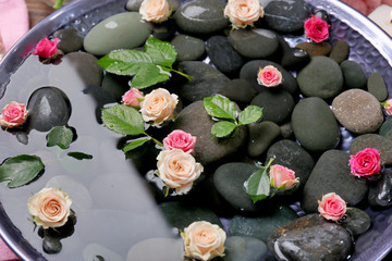 Spa composition of flowers and stones in water, close-up