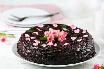 Chocolate cake decorated with flowers on the table