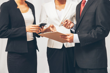 three business people standing and discussing their work