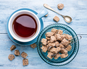 Cup of tea and cane sugar cubes.
