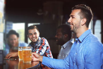 Young men drinking beer in pub