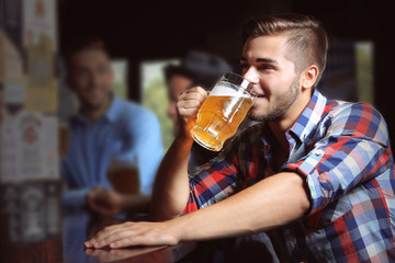 Young men drinking beer in pub