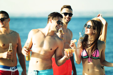 Fototapeta premium Young people with drinks on the riverside