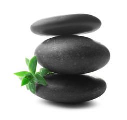 Stack of stones and a green flower, isolated on white. Spa relaxation concept