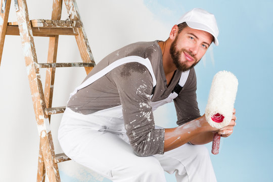 Smiling handsome painter with paint brush