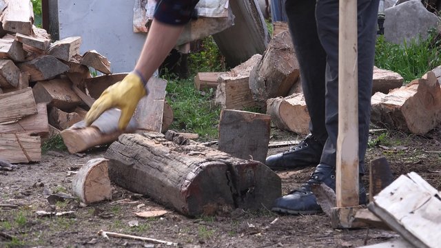 Lumberjack cutting wood with axe, male worker splitting logs outdoors