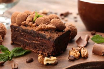 A piece of chocolate cake with walnut and mint on the table, close-up