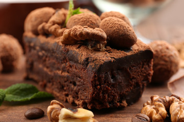 A piece of chocolate cake with walnut and mint on the table, close-up