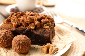 A piece of chocolate cake with walnut on the table, close-up