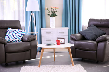 Modern living room interior with coffee table, armchairs and stand