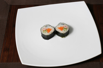 portion sushi on a large square white plate