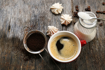 Cup of coffee with sweets on wooden background