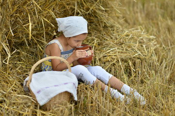 Naklejka na ściany i meble Little girl with milk in field