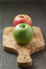 green and red apple on olive board