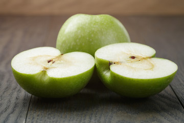 ripe green apples sliced on wood table