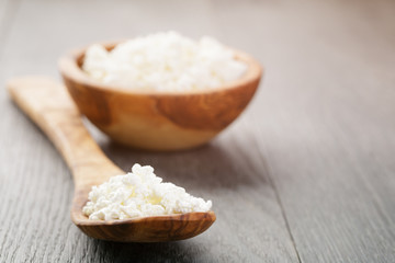 fresh cottage cheese in a wood bowl on a wooden table