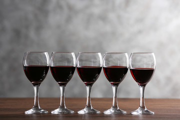Half full wine glasses on table on light background