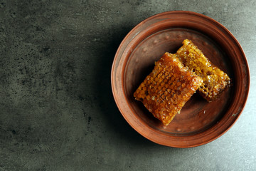 Honeycombs on plate on gray background