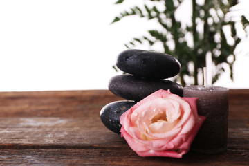 Spa stones, a candle and a rose, isolated on white
