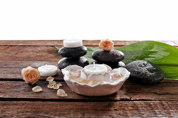 Fototapeta na wymiar Spa composition of stones, candles and a rose, isolated on white