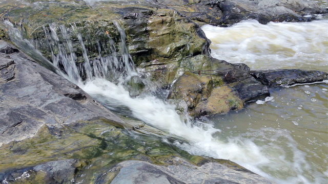 Mountain stream between stones. Little rapids.