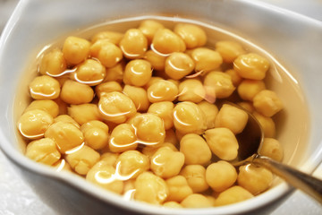 Canned corn and juice in a white bowl, on the table, close-up