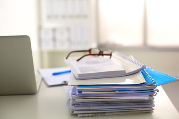 Office table with blank notepad and laptop 