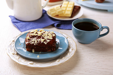 Delicious chocolate brownie on plate on wooden background