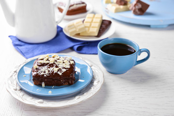 Delicious chocolate brownie on plate on wooden background
