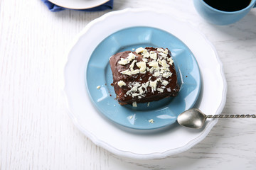 Delicious chocolate brownie on plate on wooden background