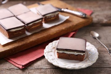 Delicious chocolate brownies on plate, on wooden background