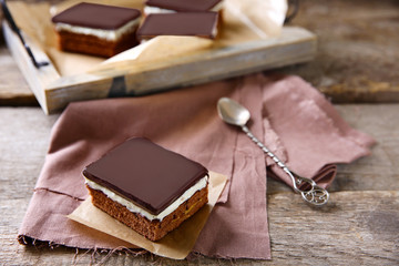 Delicious chocolate brownies on tray, on wooden background