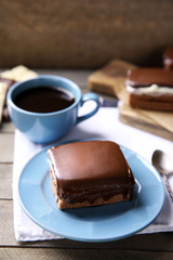 Delicious chocolate brownie on plate on wooden background