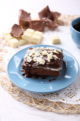 Delicious chocolate brownie on plate on wooden background