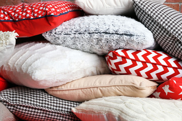Multicoloured pillows on a brick wall background