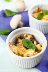 French dish julienne. Mushroom, chicken and cheese gratin in ceramic bowls, on wooden background