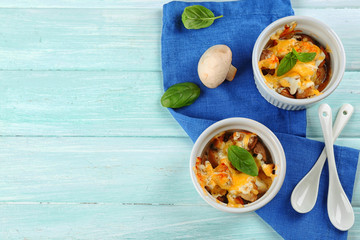 French dish julienne. Mushroom, chicken and cheese gratin in ceramic bowls, on wooden background