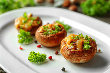 Stuffed mushrooms on plate, on table background