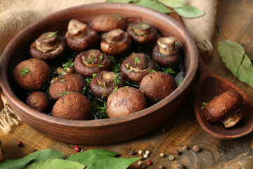 Baked champignons mushrooms with butter, parsley and roasted garlic in brown bowl