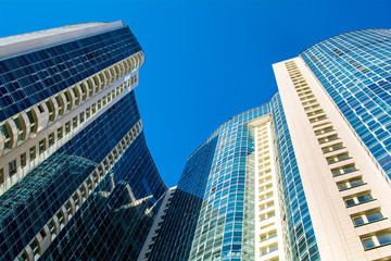 Fototapeta premium High-rise residential building on a background of blue sky. Photo from a lower angle. 